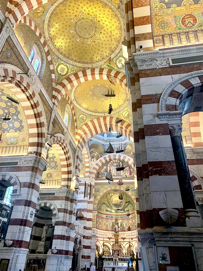 intérieur de la basilique N-D de la Garde, nombreux ex-voto de bateaux suspendus.