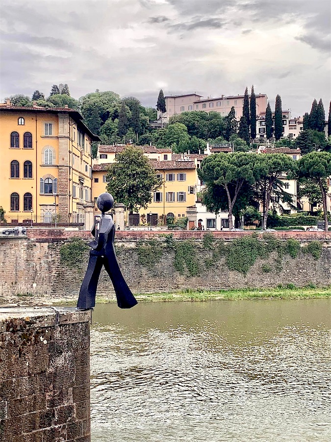 statue de bronze représentant un personnage marchant au bord d'un quai avec un pied dans le vide, Italie