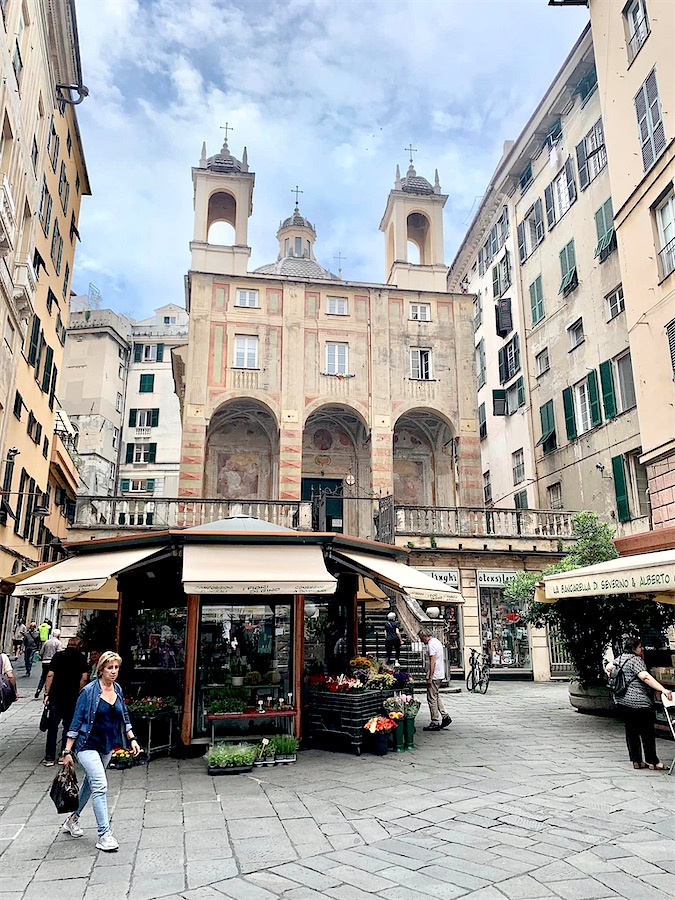 place avec kiosque vendant fleurs et plantes, église en fond